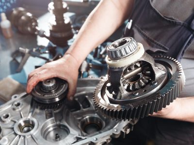 Cross-section of a car gearbox. mechanics work in the garage. hand car mechanic in working clothes.
